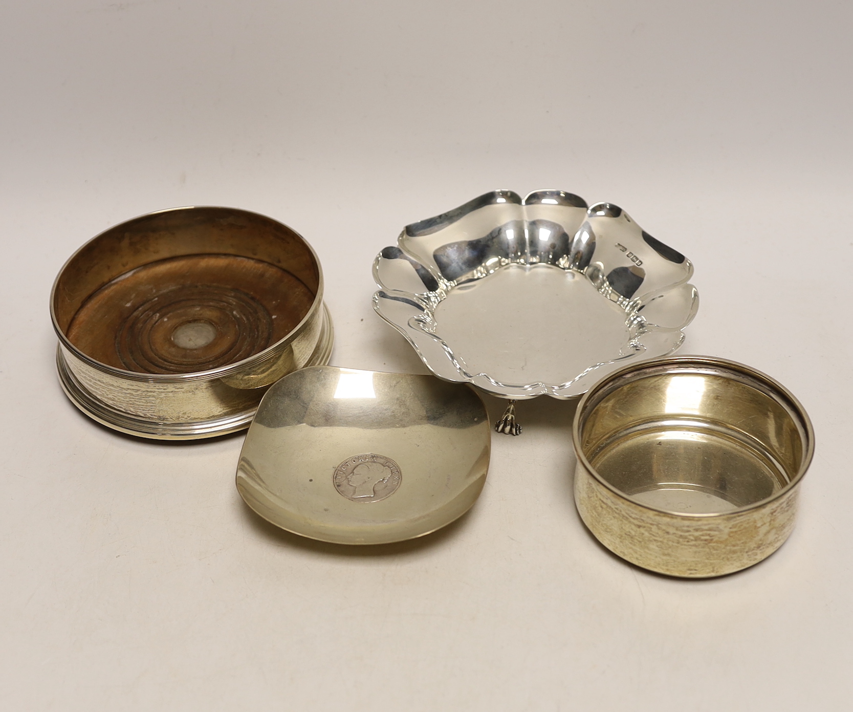 A small George V silver bowl, Sheffield, 1934, a silver bottle coaster, a small Indian white metal dish with inset rupee coin and a further small silver christening bowl.